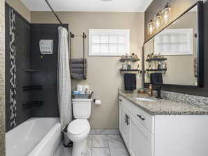 Full bathroom featuring shower / bath combination with curtain, vanity, and toilet