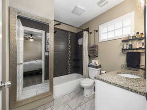 Full bathroom featuring vanity, toilet, and shower / bathtub combination with curtain