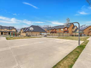 View of sport court with a playground and a yard