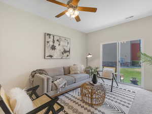 Living room with carpet floors and ceiling fan