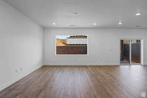 Empty room featuring hardwood / wood-style floors and a healthy amount of sunlight