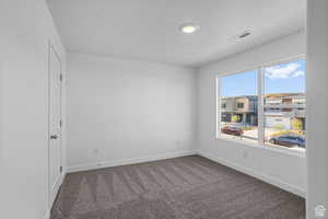 Carpeted empty room featuring a textured ceiling