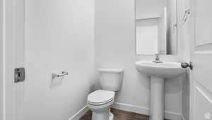 Bathroom featuring sink, toilet, and hardwood / wood-style floors