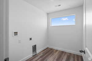 Laundry area with hookup for a washing machine, dark hardwood / wood-style floors, and hookup for an electric dryer