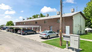 View of vehicle parking with a yard and a mail area