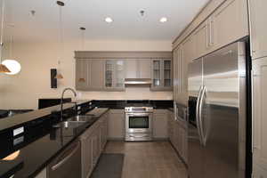 Kitchen featuring pendant lighting, sink, gray cabinets, and stainless steel appliances