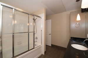 Bathroom featuring vanity and combined bath / shower with glass door