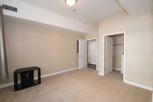 Unfurnished bedroom featuring light colored carpet and a closet