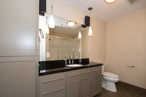 Bathroom with vanity, tile patterned floors, toilet, and walk in shower