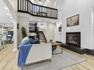 Living room featuring a high ceiling and light hardwood / wood-style floors