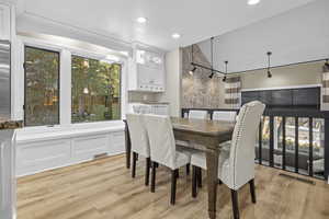 Dining space with light hardwood / wood-style flooring and a textured ceiling