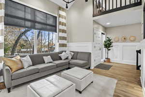 Living room with light hardwood / wood-style floors and a high ceiling