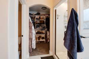 Bathroom with toilet, tile patterned flooring, and a shower with door