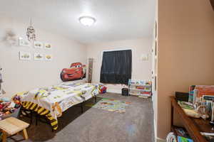 Bedroom with carpet floors and a textured ceiling