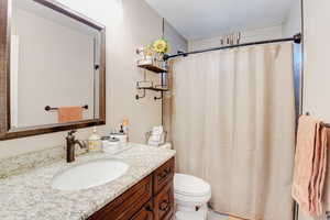 Bathroom featuring vanity, a textured ceiling, and toilet
