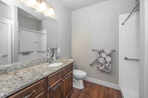 Bathroom featuring vanity, toilet, hardwood / wood-style floors, and walk in shower