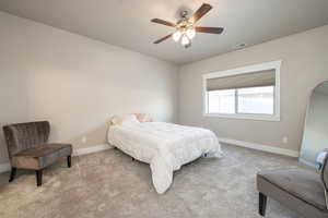 Bedroom featuring light colored carpet and ceiling fan