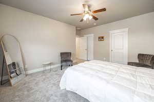 Carpeted bedroom featuring ceiling fan