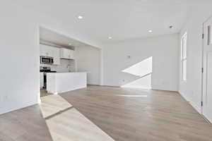 Unfurnished living room with sink and light hardwood / wood-style floors