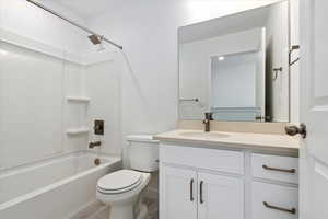 Full bathroom featuring vanity, shower / washtub combination, and toilet