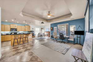 Living room featuring ceiling fan and a tray ceiling