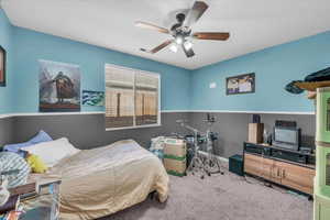 Carpeted bedroom featuring ceiling fan