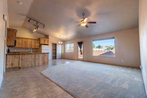 Kitchen with white refrigerator, a healthy amount of sunlight, a textured ceiling, and decorative light fixtures