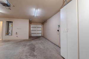 Garage featuring a garage door opener and gas water heater