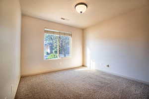 Carpeted spare room with a textured ceiling