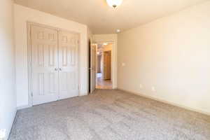 Unfurnished bedroom featuring carpet flooring and a closet