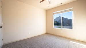 Spare room featuring carpet flooring and ceiling fan