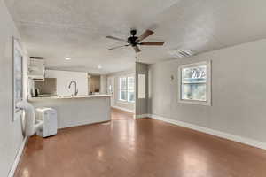 Kitchen with kitchen peninsula, sink, hardwood / wood-style floors, and white cabinets