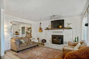 Tiled living room with a textured ceiling and a wood stove