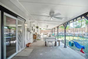 Unfurnished sunroom featuring ceiling fan