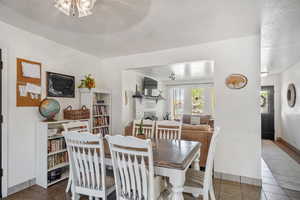 Tiled dining room featuring a textured ceiling and a fireplace