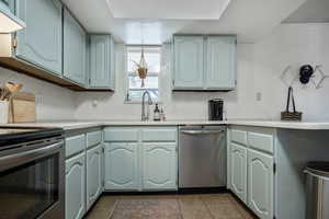 Kitchen with tasteful backsplash, tile patterned floors, appliances with stainless steel finishes, and sink