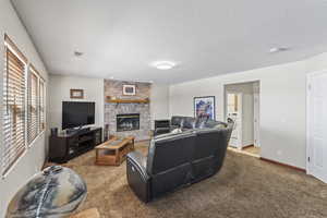 Carpeted living room featuring a cozy fireplace