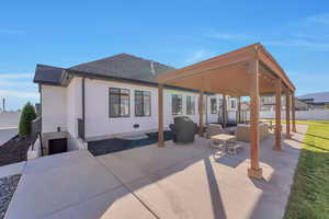 Back of house with an outdoor living space with a fireplace and a patio area