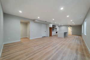 Unfurnished living room with sink and light hardwood / wood-style floors