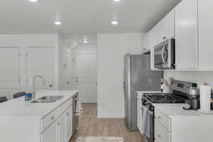 Kitchen finished with quartz countertops, stainless steel appliances, modern cabinetry with hardware, and pantry