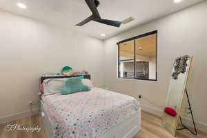 Bedroom with ceiling fan and light hardwood / wood-style flooring