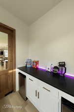 Kitchen featuring white cabinetry, light hardwood / wood-style flooring, and fridge