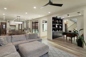 Living room with ceiling fan, sink, and light hardwood / wood-style flooring