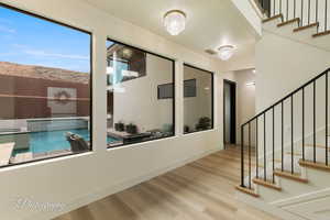 Hall featuring an inviting chandelier and light hardwood / wood-style floors