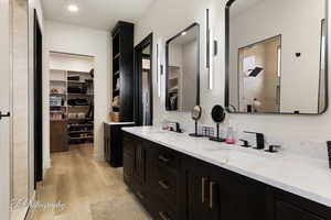 Bathroom featuring vanity, wood-type flooring, and a shower