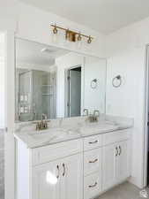 Bathroom featuring vanity, a shower with shower door, and tile patterned floors