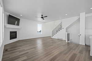 Living room featuring ceiling fan, a fireplace, and hardwood / wood-style floors