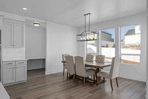 Dining area featuring an inviting chandelier, plenty of natural light, dark hardwood / wood-style flooring, and a textured ceiling