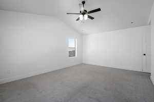 Unfurnished room with vaulted ceiling, ceiling fan, and carpet flooring