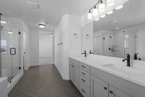 Bathroom with vanity, a textured ceiling, ceiling fan, and a shower with shower door